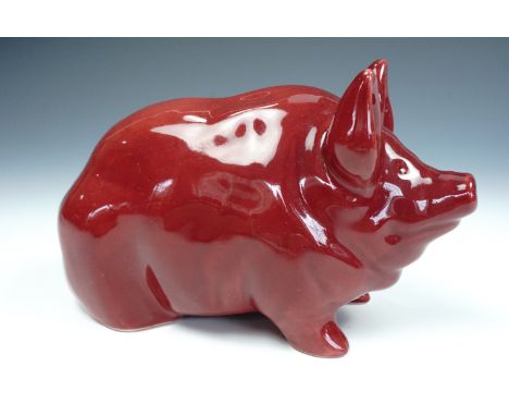 A Robert Heron and Sons Wemyss Ware pottery pig, modelled in a seated position, with puce glaze, impressed marks, 11 cm high,