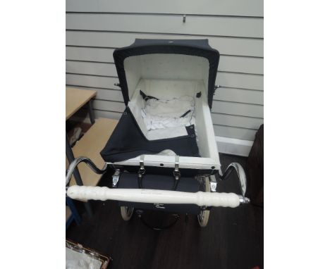 A vintage Silver Cross dolls pram having dark blue body and canopy with travel bag on double axel sprung chassis 