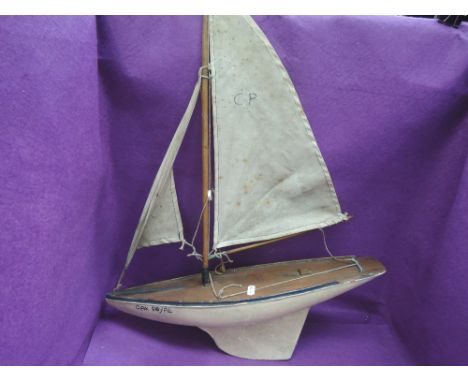 A vintage wooden pond yacht having sail 