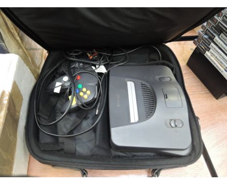 A vintage Nintendo 64 with controller and wiring along with a selection of games in original carry case