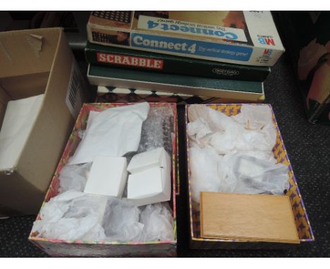 Two small boxes of modern wooden and plastic dolls house furniture, three vintage games and a tennis racket