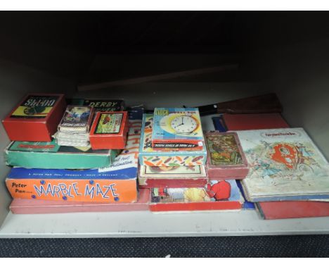 A shelf of vintage children's games and toys including Peter Pan Marble Maze, Fairyland Puzzle Book, Chad Valley Derby Winner