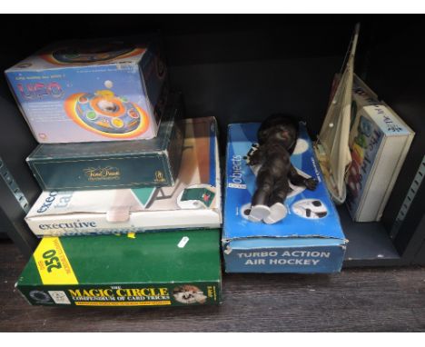 A shelf of mixed vintage games and toys including The Magic Circle, Trivia Pursuit, Roddy black baby doll etc