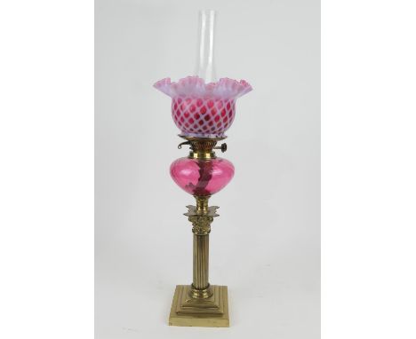 Victorian brass and cranberry glass pedestal oil lamp, frilled white and cranberry lattice shade over a cranberry tank and Co