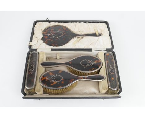 George V silver and pique tortoiseshell vanity set, Birmingham 1919, comprising hand mirror, two hair brushes, two clothes br