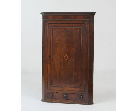 Provincial oak and inlaid flat front hanging corner cupboard, early 19th Century, having a mahogany frieze, single door with 