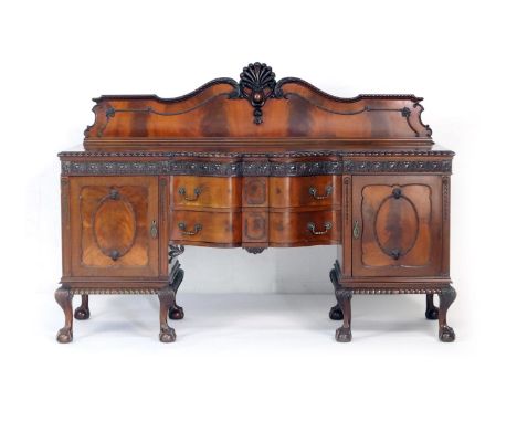 Chippendale Revival mahogany serpentine sideboard, circa 1910, having a carved moulded back, two central drawers flanked by m