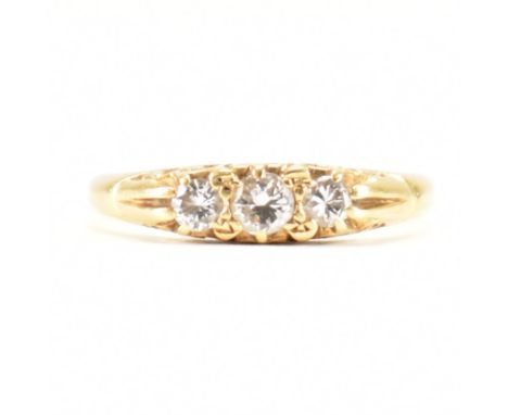 A hallmarked 18ct yellow gold &amp; diamond three stone ring. The ring having a central round cut diamond flanked by graduati