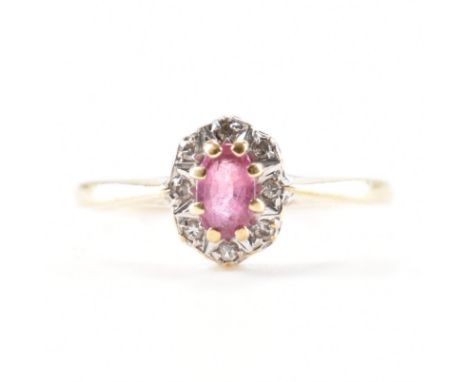 A hallmarked 9ct gold ruby and diamond halo ring. The ring being set with an oval cut ruby with a halo of diamond accent ston