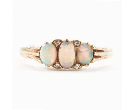 A hallmarked 9ct yellow gold, opal &amp; diamond ring. The ring having three graduating oval cut opal cabochons spaced by fou