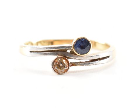 A vintage 18ct yellow &amp; white gold, diamond &amp; blue stone crossover ring. The ring having a round cut diamond &amp; bl