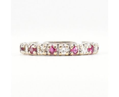 A French ruby and diamond eternity ring. The ring set with 11 ruby and 11 diamonds to an 18ct gold band. Partial French contr