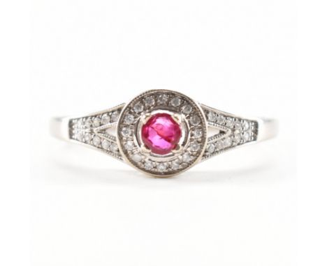 A white gold ruby and diamond ring. The ring being set with a round cut ruby to the centre surrounded by diamonds to the head