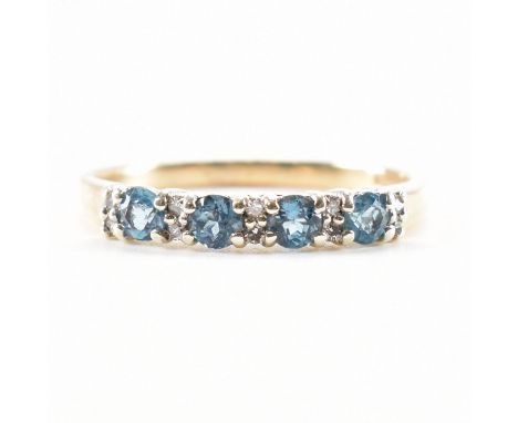 A hallmarked 9ct gold aquamarine and diamond set ring. The ring being set with four round cut aquamarines with diamond accent