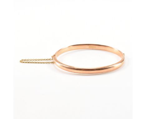 A Victorian hallmarked 15ct rose gold bracelet bangle. The hinged bangle of D form having a box clasp &amp; safety chain. Hal