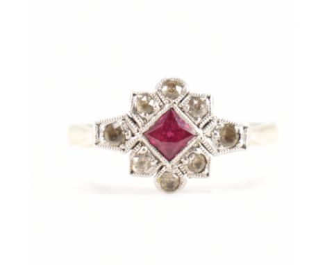 A 1920s 9ct yellow gold, platinum, ruby &amp; topaz ring. The ring having a central square cut millegrain set ruby surrounded