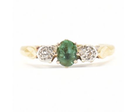 A vintage 18ct gold and platinum green stone and diamond ring. The ring being set with a central oval cut green stone flanked