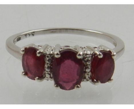 A 9 carat white gold and ruby three stone ring. 