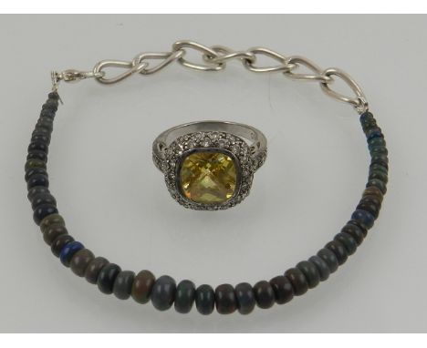 A black opal beaded bracelet, together with a silver and cubic zirconia set cocktail ring. 