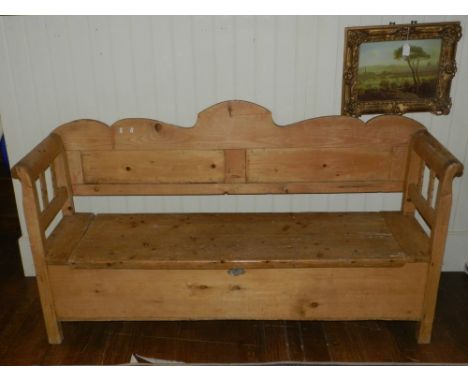 A 19th century pine box seat settle, with a shaped panel back, and raised on block feet, 184cm