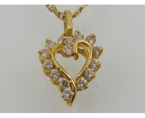 A yellow gold and diamond set heart-shaped pendant, suspended on a yellow gold chain.
