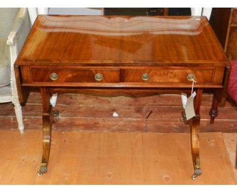 A George III style mahogany sofa table, the rectangular cross banded top above two drawers, on slab supports and in sabre leg