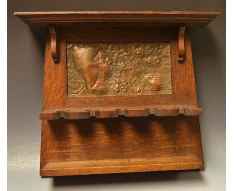 An Arts and Crafts oak and beaten copper pipe rack, embossed with a man blowing sinuous smoke rings, c.1910 