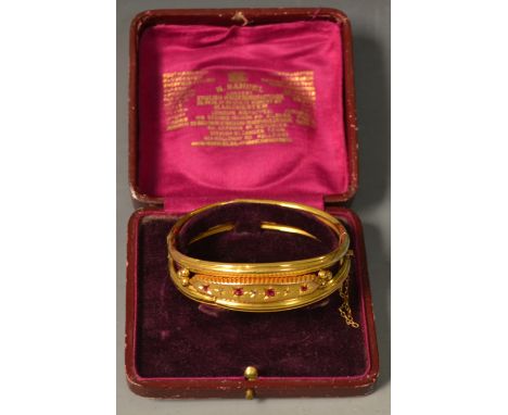 An Edwardian diamond chip and ruby seven stone hinge bangle, arched body set with alternating ruby's and diamonds, unmarked y