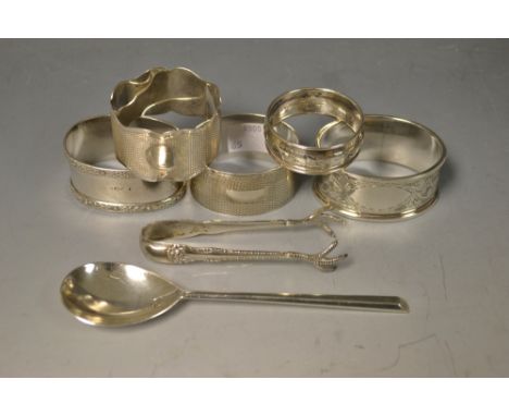 A silver anointing spoon, marked London 1953; a pair of silver sugar tongs, Birmingham 1896; a silver napkin ring, engine tur