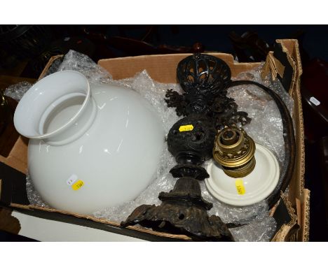 A LATE 19TH CENTURY WROUGHT IRON OIL LAMP, with a white ceramic reservoir and glass shade