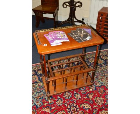 AN EDWARDIAN WALNUT CANTERBURY, the brass gallery top raised on four tapering cylindrical uprights and ceramic casters, width