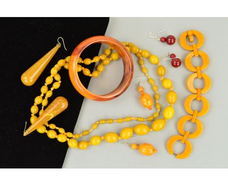 A SELECTION OF PLASTIC JEWELLERY to include a circular disc bracelet in dark yellow bakelite, a long graduated bead necklace 