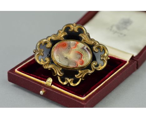 A LATE VICTIORIAN BROOCH, the gold plated brooch with replacement oval agate centre panel within a black enamel surround to t