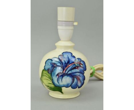 A SMALL MOORCROFT POTTERY TABLE LAMP, 'Hibiscus' pattern on cream ground, impressed and painted blue marks to base, height 17