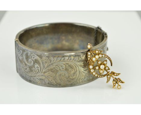 A BROOCH AND A BANGLE to include an early 20th Century gold seed pearl brooch designed as a crescent moon, flower and leaves 