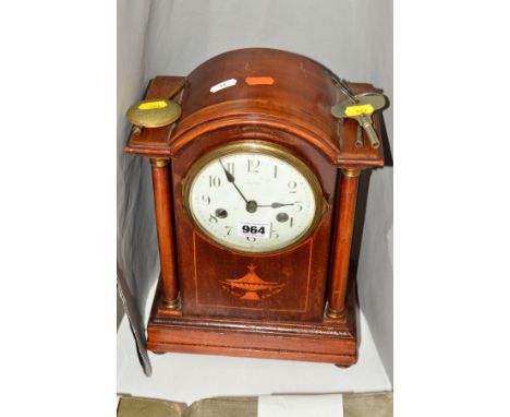 A MAHOGANY MANTLE CLOCK, the dome topped pediment on two pillars, the body inlaid with twin handled urn, white enamel dial wi