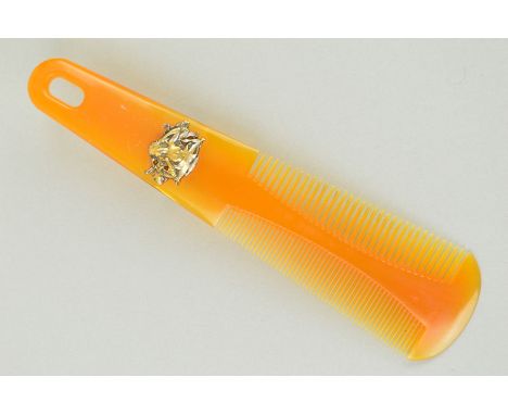 AN EARLY 20TH CENTURY COMB of tapered outline with two different sized teethh comb to either side and an Art Nouveau plaque d