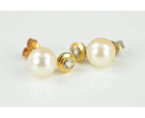 A PAIR OF CULTURED PEARL AND DIAMOND EARRING STUDS, each designed as a cultured pearl with a circular panel beneath collet se