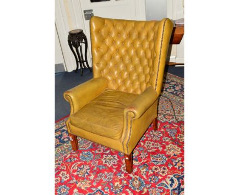 AN EARLY 20TH CENTURY OLIVE GREEN LEATHER BUTTON BACK ARMCHAIR, with an arched back