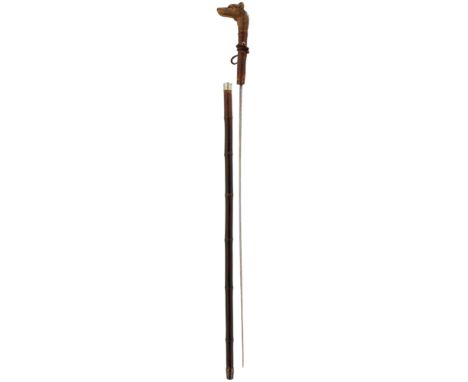 AN EDWARDIAN SWORD STICK, 68cm fullered blade with foliate decoration highlighted in gilt, the wood handle carved as a dog's 