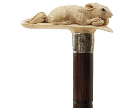 A LATE 19TH/EARLY 20TH CENTURY WALKING STICK, the handle carved as a mouse protecting a cache of nuts, above engraved white m