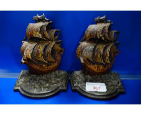 A PAIR OF VINTAGE CAST IRON BOOK-ENDS in the form of galleons