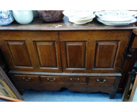 A GEORGE II STYLE OAK CONVERTED MULE CHEST, rectangular top above two panelled cupboards, fitted with a single shelf, below o