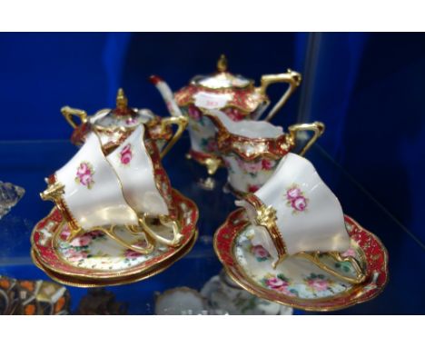 A NORITAKE CABARET TEA SET, with rose decoration within a red and gilt border