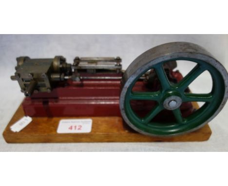 STUART; A VINTAGE MODEL STEAM ENGINE the base painted red, on a wooden base, 24cm wide (inc base)
