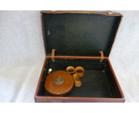 A SMALL VINTAGE LEATHER SUITCASE, a leather covered tape measure and four pieces of mauchline ware