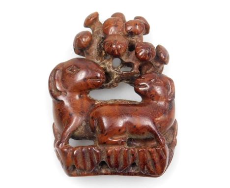 A 20thC Japanese style hardwood netsuke, carved as a ewe and ram beneath a tree, 4cm wide.