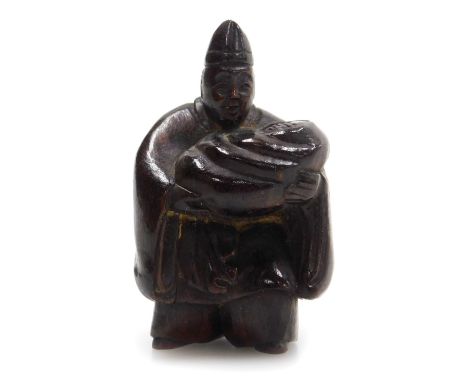 A contemporary Japanese style hardwood netsuke, of a man holding a baby in a swaddling blanket, 4.5cm high. .