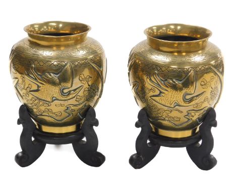 A pair of early 20thC Chinese heavy brass vases, embossed with a deer, bamboo, trees and a crane, the bases with seal script 