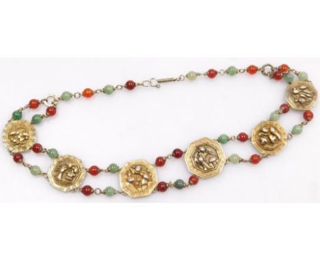 A 20thC Chinese gilt metal, jade and red hardstone necklace, formed as six octagonal links, with varying embossed decoration,